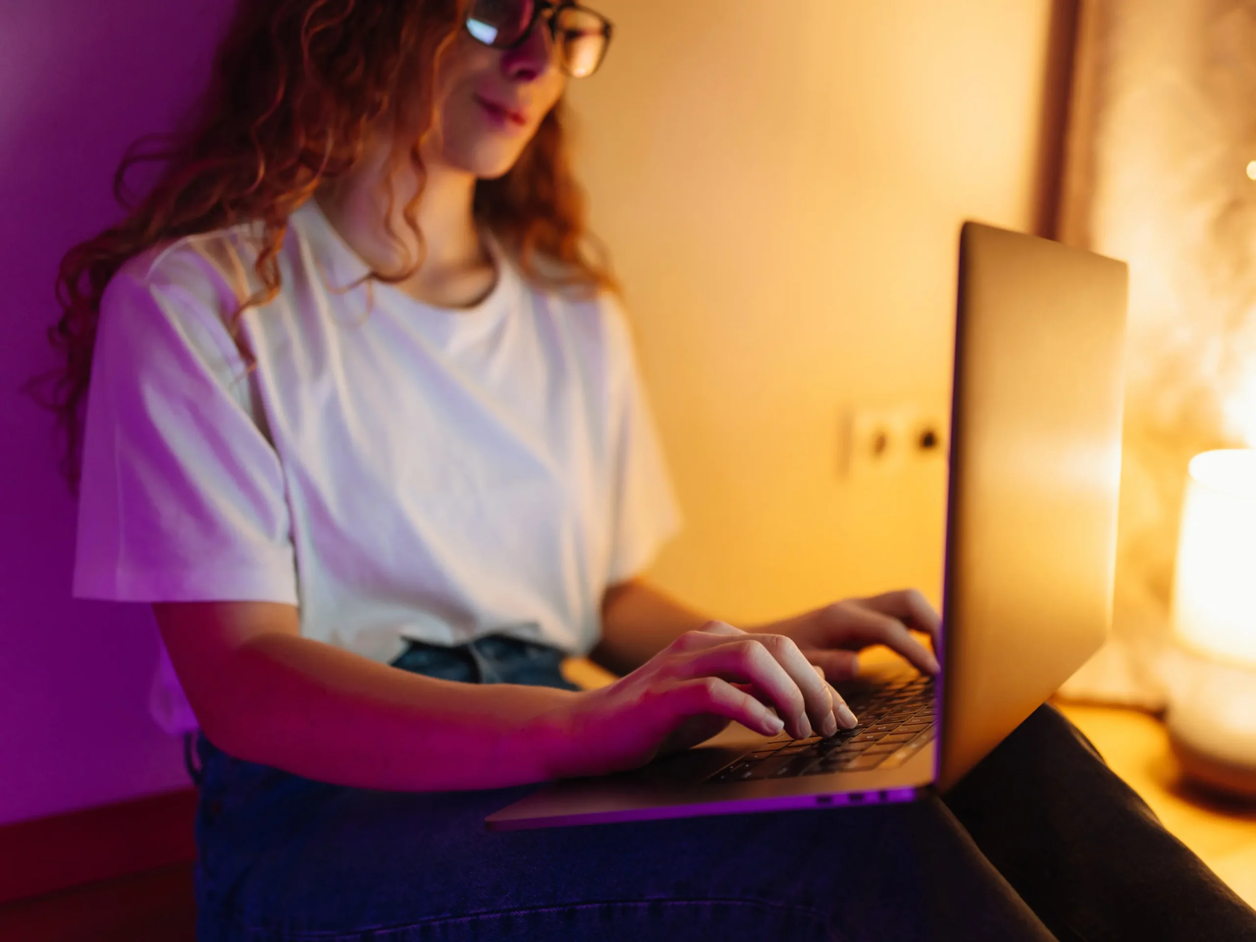 Mujer creadora de Fanvue escribiendo en su laptop, representando una agencia fanvue segura y confiable